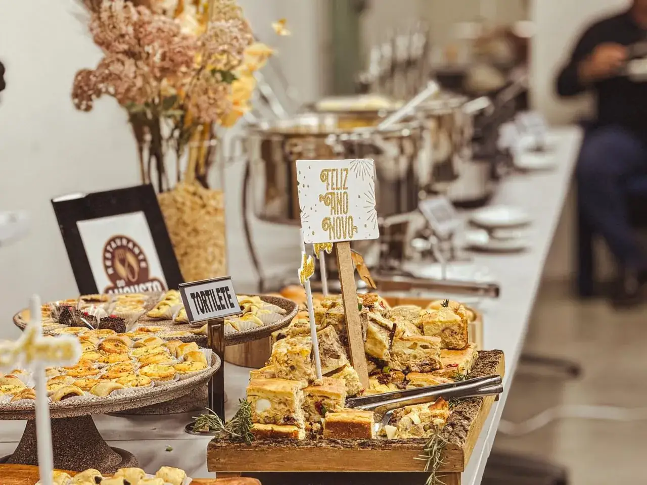 Mesa de buffet do Augusto com entradas, pães e detalhes de uma recepção